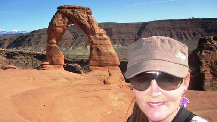 A solo traveler hiking in Arches National Park.