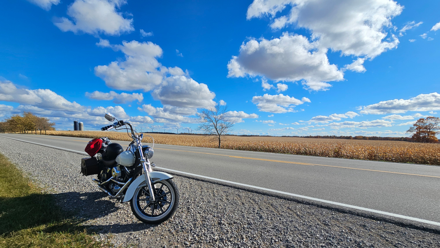 Blue skies and fluffy clouds above a bike on a solo motorcycle trip