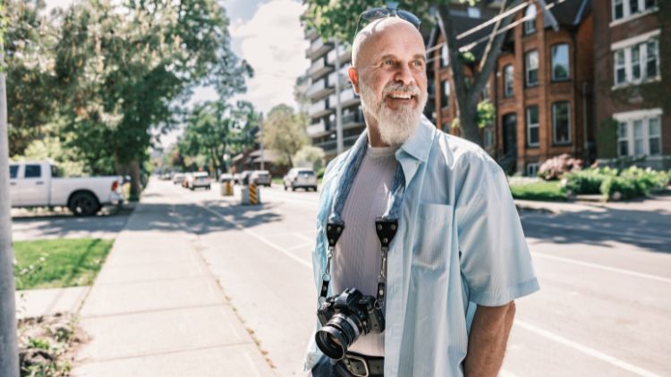 man with camera on street. When you can't travel you can still explore close to home