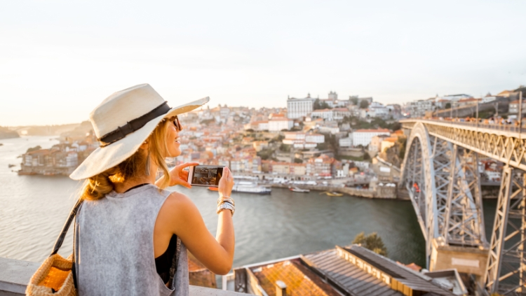 female solo traveler over 50 taking a photo with her phone