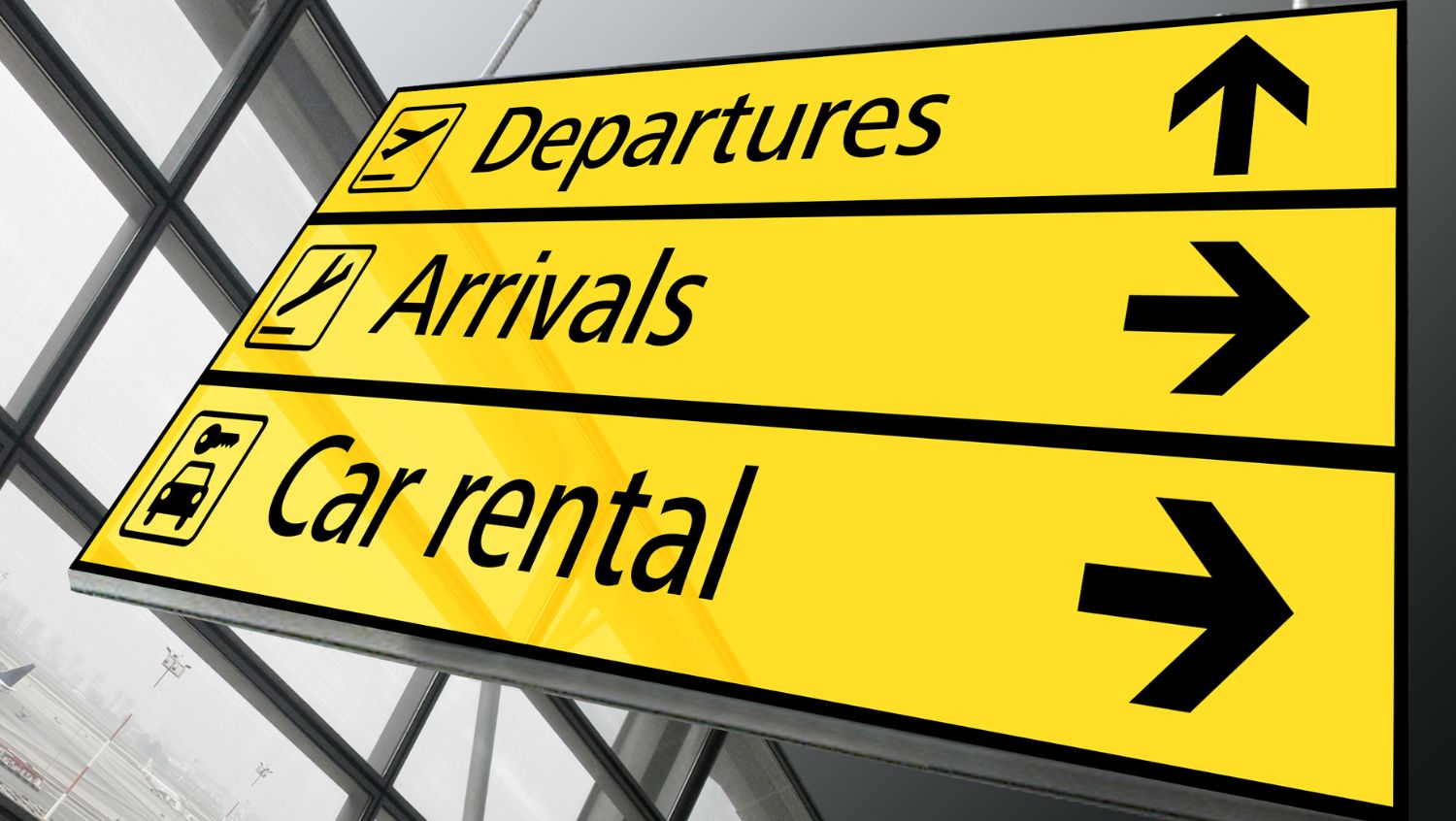 Signs at an airport pointing to departures, arrivals, and car rentals