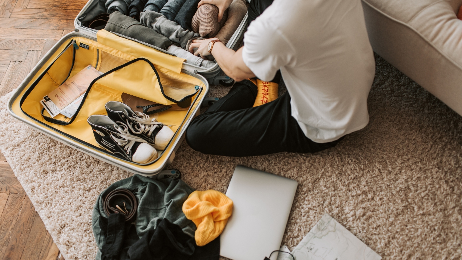 man sitting on floor, packing carry-on bag