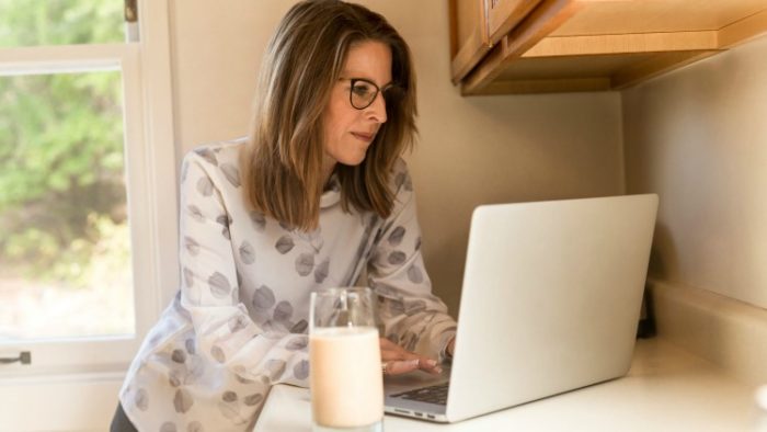 woman using laptop in kitchen