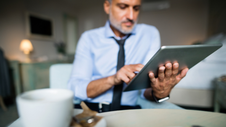 man with tablet in hotel room, solo business travel